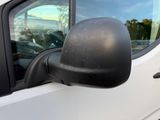 a side view mirror of a white truck with a reflection of a person in the window