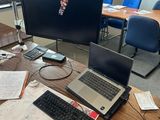 un bureau sur lequel se trouvent un ordinateur portable, un clavier, une souris et d'autres objets