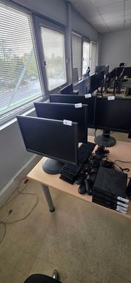 many computers on the desks in the room