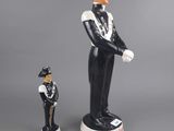 a statue of a man in a uniform next to a small figurine of a man