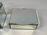 pair of mirrored boxes with flowers in them sitting on a white surface