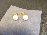 une paire de boucles d'oreilles en perles posée sur un oreiller