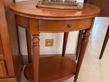 une petite table sur laquelle est posé un livre, à côté d'une commode