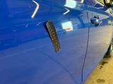 a close up of a blue car with a sticker on it