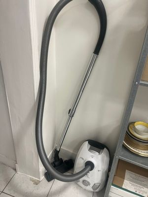 a vacuum that is sitting on the floor next to a shelf