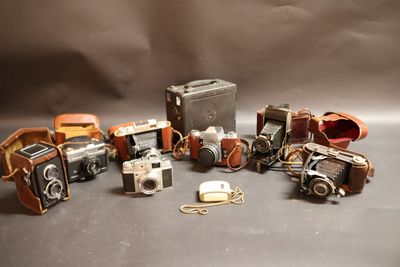 de nombreux modèles d'appareils photo et d'étuis posés sur la table
