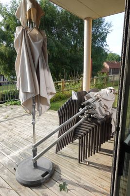 un parapluie posé sur une table de la terrasse