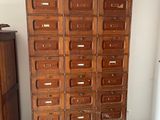 a tall wooden cabinet with many drawers in it