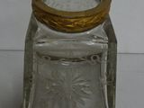 a glass jar with a gold lid sitting on a table