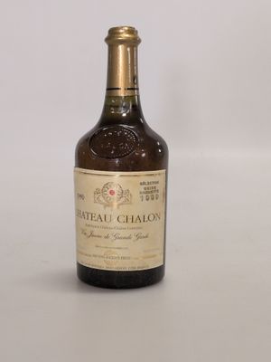 une vieille bouteille de vin de Château-Chalon posée sur une surface blanche