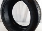 a close up of a tire on a white surface with a white curtain in the background