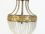 un lustre suspendu au plafond, sur lequel est perché un oiseau