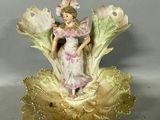 a figurine of a woman sitting on a flower
