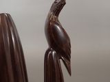 a wooden sculpture of a bird sitting on top of a piece of wood
