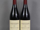 two bottles of wine sit on a glass table