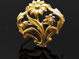 une bague en or ornée de fleurs et de feuilles sur un fond noir