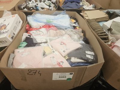 Des cartons de vêtements sont empilés les uns sur les autres dans un magasin
