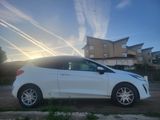 a white car parked in front of a house with a sky background
