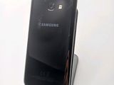 a black samsung phone that is sitting on a stand