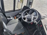 a view of the driver ' s seat and dashboard of a bus