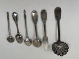 several spoons, forks and spoon spoons are lined up on a white surface