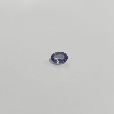 a blue sapphire stone on a white surface