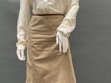 an image of a mannequin wearing a tan skirt and a white blouse