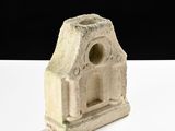 a small stone sculpture of a building on a white table
