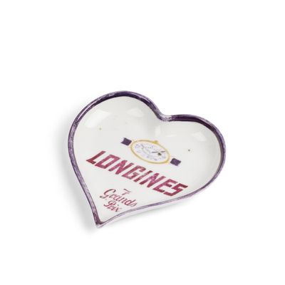 un cendrier blanc en forme de cœur sur lequel est inscrit le mot « Longines »