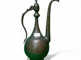 a green vase with a bird on it on a white surface
