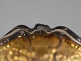a glass vase that has a gold decoration on it