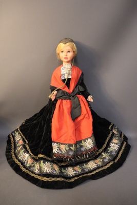 an image of a doll of a woman in a black and orange dress