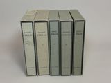 four books are stacked on top of each other on a white surface