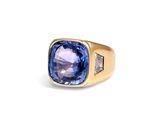 gros plan d'une bague avec une pierre bleue et des diamants