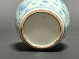 a blue and white vase sitting on a gray surface