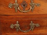 a wooden chest of drawers with brass handles on it