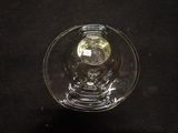a glass bowl with a candle inside of it on a black surface