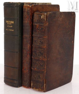 two old books sitting on top of each other on a table