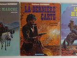 trois livres posés contre un mur, avec un cow-boy à cheval et un cow-boy à cheval