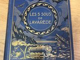 Le livre « Les 5 sous de Lavarède » est posé sur une table.