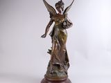 a bronze statue of a woman holding a bird on top of a wooden base