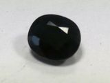 a close up of a black stone on a white surface