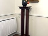 un vase posé sur un socle dans une pièce où se trouve un radiateur