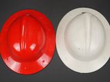 two hard hats sitting next to each other on a table