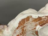 a white and brown vase with a black hole in it