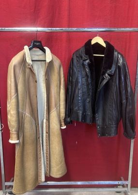 deux manteaux suspendus à un porte-manteau devant un mur rouge