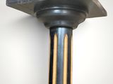 a metal pole with a black top and two wooden poles