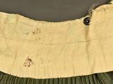 a close up of a pleated skirt with a button on it