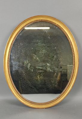 un miroir rond avec un cadre doré accroché au mur
