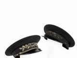 pair of black military hats on a white background